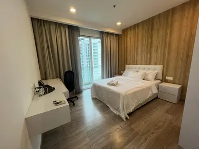 a bedroom with a bed and a desk and a window at MyRehat Suites Bukit Ceylon in Kuala Lumpur