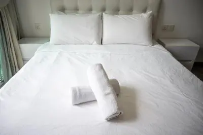 a towel on a bed with a sock on it at MyRehat Suites Bukit Ceylon in Kuala Lumpur