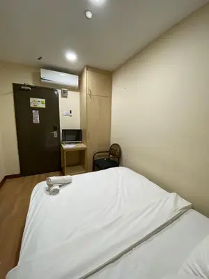 a room with a bed with a white sheet on it at Hotel Ambassador @ Bukit Bintang in Kuala Lumpur