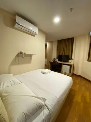 a large white bed in a room with a desk at Hotel Ambassador @ Bukit Bintang in Kuala Lumpur