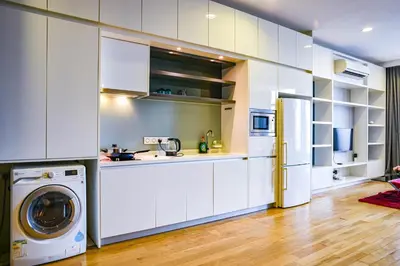 a kitchen with white cabinets and a washer and dryer at Sidemen Suites at Platinum KLCC in Kuala Lumpur