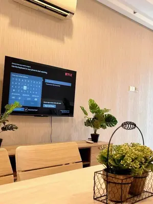 a projection screen on a wall with two potted plants at Seputeh Cozy & Homely VIVO Suite Old Klang Road Near MidValley, The Garden Mall in Kuala Lumpur