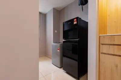 a kitchen with a black refrigerator and a microwave at Datum Jelatek Balcony w Infinity Pool Linked LRT KLCCView Mall in Kuala Lumpur
