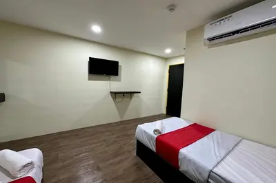 a room with two beds and a tv on the wall at Hotel MSP Bukit Bintang in Kuala Lumpur