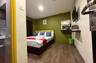 a bedroom with a bed in a room with green walls at Hotel MSP Bukit Bintang in Kuala Lumpur
