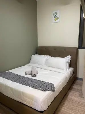 a large bed with white sheets and white pillows at Cozy Family Suite Kepong DesaPark MontKiara Publika Mitec in Kuala Lumpur