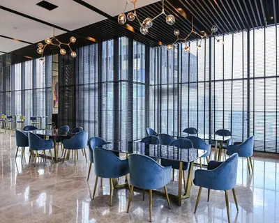 a dining room with blue chairs and tables and large windows at Star Residence Apartment with twin towers KLCC view in Kuala Lumpur