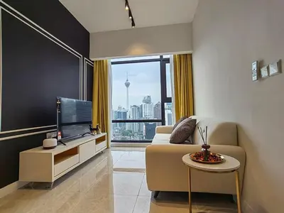 a living room with a couch and a tv and a table at The Axon Bukit Bintang by SMOVF BNB in Kuala Lumpur