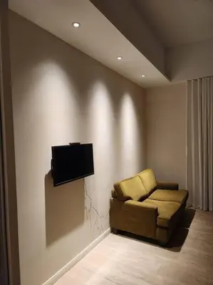 a living room with a couch and a television on a wall at M City Minimalist KLCC Suite in Kuala Lumpur