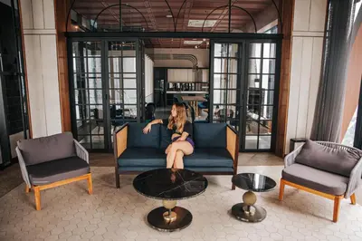 a woman sitting on a couch in a living room at Scarletz Leisure Suites KLCC in Kuala Lumpur