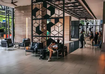 a man sitting in a chair in a lobby at Expressionz Leisure Suites KLCC in Kuala Lumpur