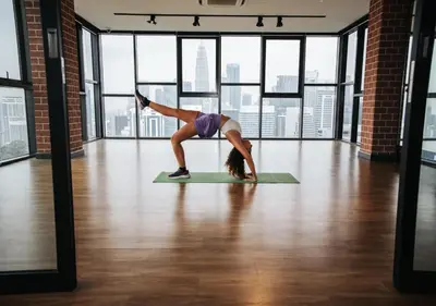 a woman doing a yoga pose on a yoga mat in a room with windows at Ceylonz Leisure Suites KLCC Bukit Bintang in Kuala Lumpur