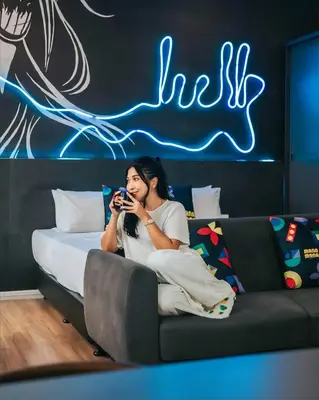 a woman sitting on a couch taking a picture with a camera at Ceylonz Leisure Suites KLCC Bukit Bintang in Kuala Lumpur