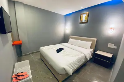 a small bedroom with a bed with white sheets at Hotel Dlima Inn Bukit Bintang in Kuala Lumpur