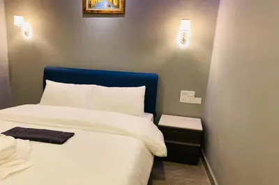 a bed with a blue headboard in a room at Hotel Dlima Inn Bukit Bintang in Kuala Lumpur