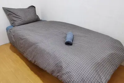 a bed with a blue object on top of it at KLCC Luxurious 2 Floors Homestay 5BR for 15pax in Kuala Lumpur