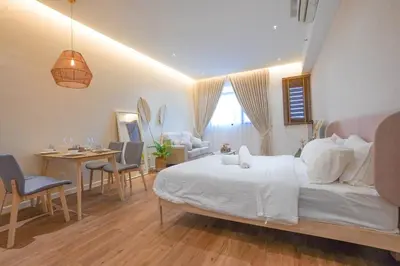 a bedroom with a white bed and a table and chairs at Chambers Suite Studio KLCC PWTC by Unimax in Kuala Lumpur