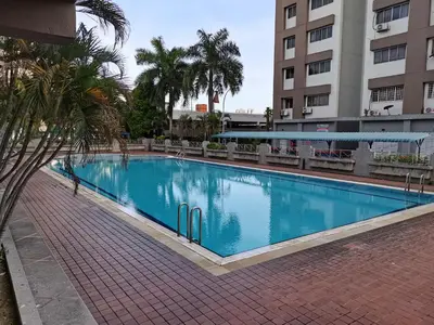 a large blue swimming pool next to a building at Ampang Hilir Lake View in Kuala Lumpur
