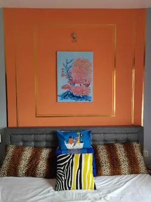 a bed with an orange headboard and two pillows at Ampang Hilir Lake View in Kuala Lumpur