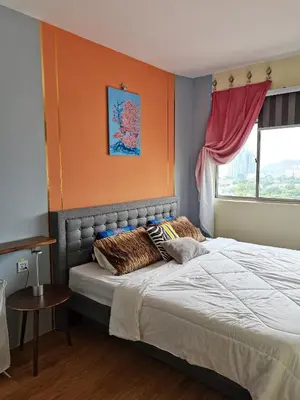 a bedroom with a large bed with an orange wall at Ampang Hilir Lake View in Kuala Lumpur