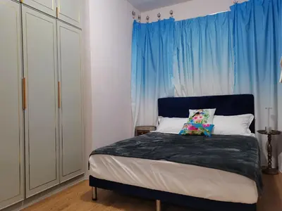 a bedroom with a bed with a blue curtain at Ampang Hilir Lake View in Kuala Lumpur