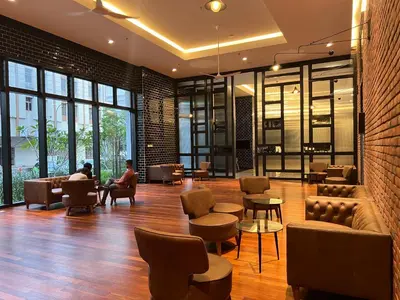 a lobby with people sitting in chairs and tables at Chambers service suites klcc in Kuala Lumpur