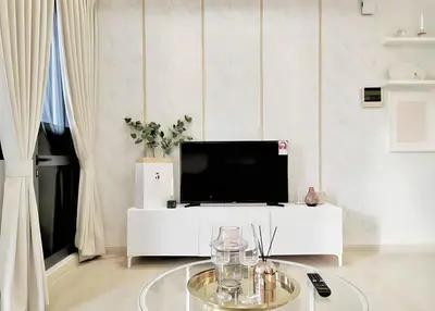 a living room with a tv and a white table at Star residance KLCC-Two bedroom Apartment in Kuala Lumpur