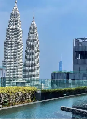 a view of the petronas twin towers from the pool at Star residance KLCC-Two bedroom Apartment in Kuala Lumpur