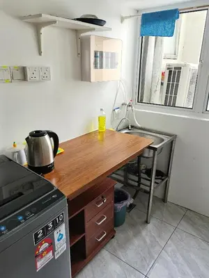a kitchen with a wooden counter top and a table at Ampang Hilir KL City Boutique Residence in Kuala Lumpur