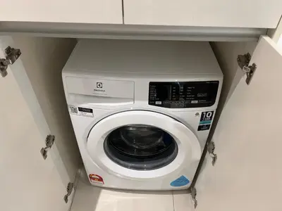 a washer and dryer in a kitchen under a counter at Chambers luxury suites KLCC in Kuala Lumpur