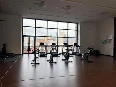 a gym with cardio equipment in front of a large window at Chambers luxury suites KLCC in Kuala Lumpur