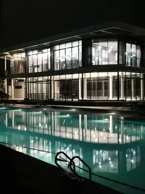 a large building with a swimming pool at night at The Harmony at Astoria Ampang - Mountain View in Kuala Lumpur
