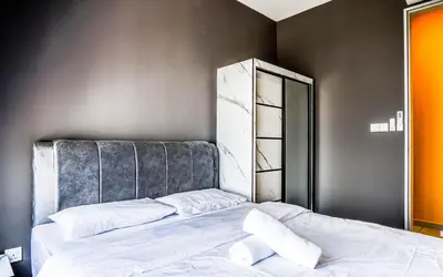 a bedroom with a bed with a headboard and a mirror at Platz @ KL North Setapak by Airhost in Kuala Lumpur