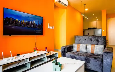 a living room with a chair and a flat screen tv at Platz @ KL North Setapak by Airhost in Kuala Lumpur