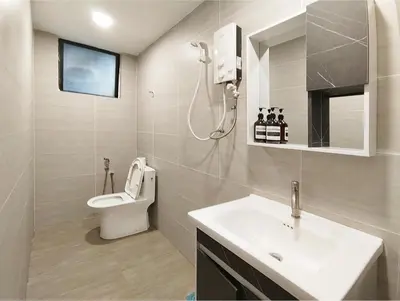 a bathroom with a white sink and a toilet at Plaza Berjaya By Manhattan Group in Kuala Lumpur