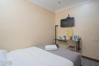 a bedroom with a bed and a desk with a television at Hotel 28 Titiwangsa in Kuala Lumpur