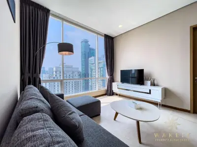 a living room with a couch and a large window at Soho Suites KLCC by Wakely Kuala Lumpur in Kuala Lumpur