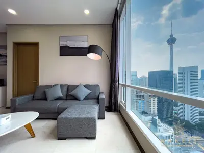 a living room with a couch and a large window at Soho Suites KLCC by Wakely Kuala Lumpur in Kuala Lumpur