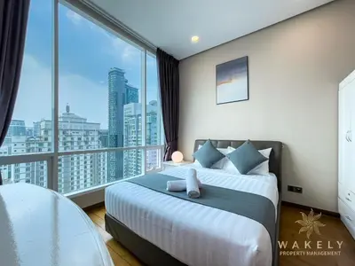 a bedroom with a bed and a large window at Soho Suites KLCC by Wakely Kuala Lumpur in Kuala Lumpur