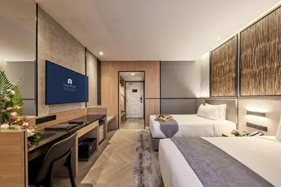 a hotel room with two beds and a desk at Hotel Royal Signature in Kuala Lumpur
