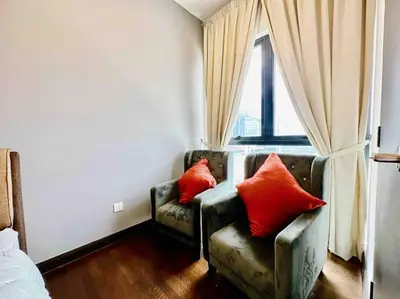 a room with a couch with two red pillows on it at Sunway Velocity Suite link velocity mall in Kuala Lumpur