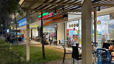 a restaurant with tables and chairs in front of a store at Balcony Unit @ Robertson Residence 18f in Kuala Lumpur