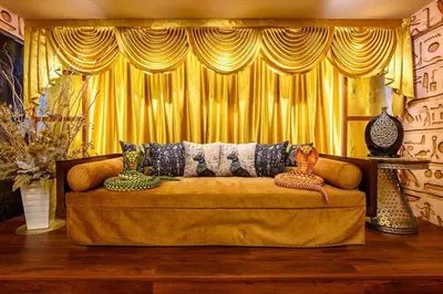 a couch in a living room with yellow curtains at Fahrenheit88 - Egypt Theme Kuala Lumpur Bukit Bintang in Kuala Lumpur