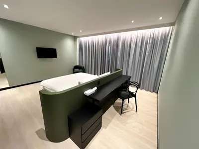 a bedroom with a bed and a desk next to a window at Crystal Crown Hotel Kuala Lumpur in Kuala Lumpur