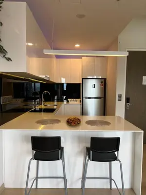 a kitchen with a counter with two bar stools at Star residance at Klcc - Two bedrooms with twin towers view in Kuala Lumpur