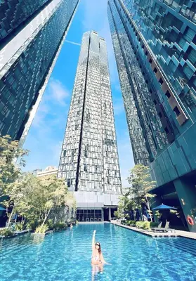 a woman in a pool in a city with tall buildings at Star residance at Klcc - Two bedrooms with twin towers view in Kuala Lumpur