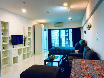 a living room with a couch and a tv at Summer Suites Apartment 7min walk to KLCC by GRIHOZ in Kuala Lumpur
