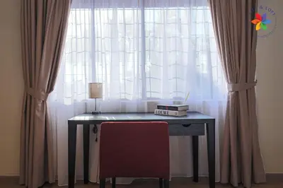 a desk in front of a window with curtains at KL Townhouse Villa by LilyandLoft in Kuala Lumpur