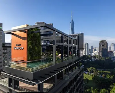 a building with a swimming pool on top of it at Hotel Indigo Kuala Lumpur on the Park by IHG in Kuala Lumpur
