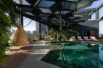 a swimming pool on the roof of a building with awning at Hotel Indigo Kuala Lumpur on the Park by IHG in Kuala Lumpur